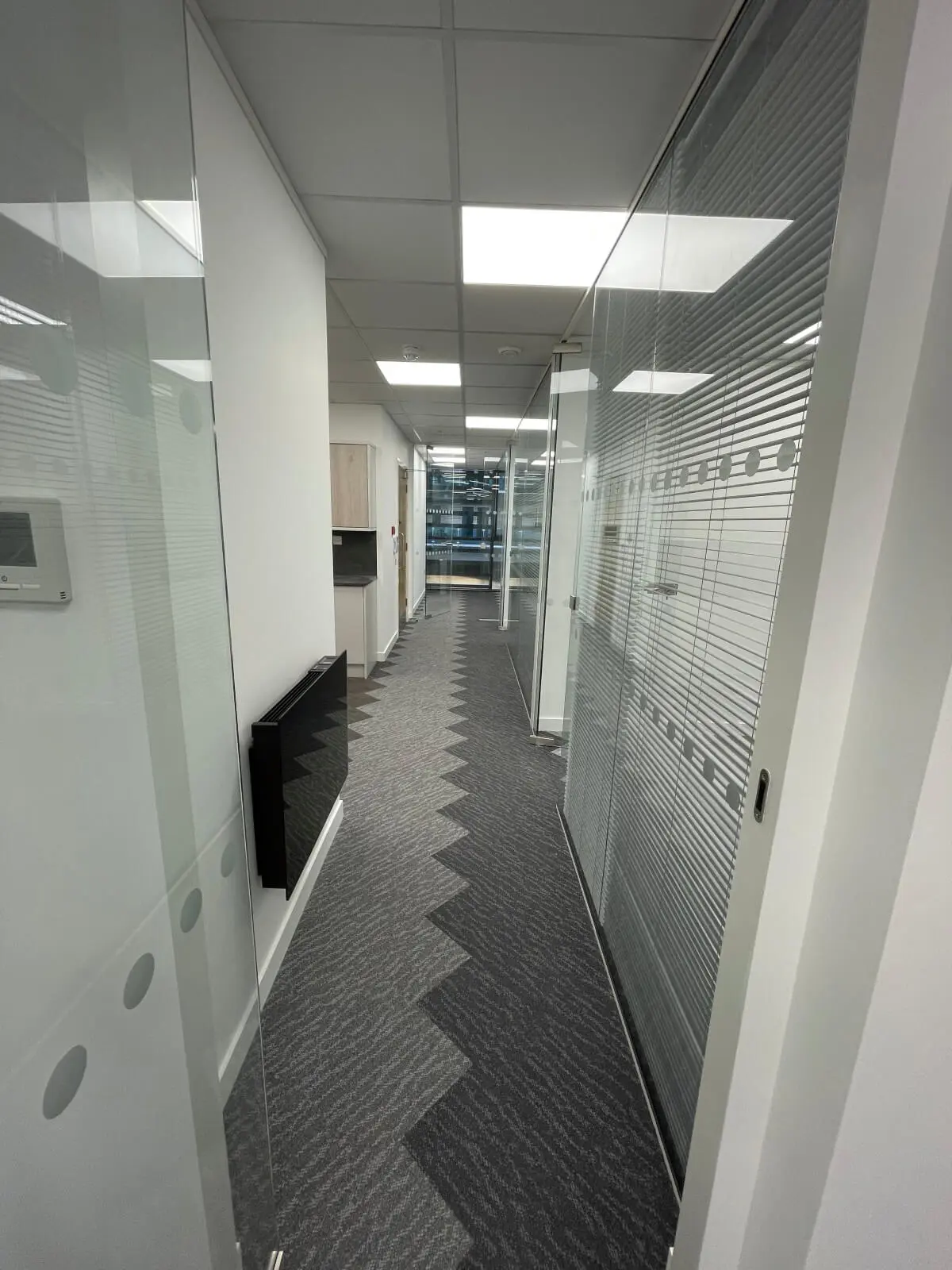 Hemsley Miller office space with designer flooring, funriture and single glazed glass partitions 13