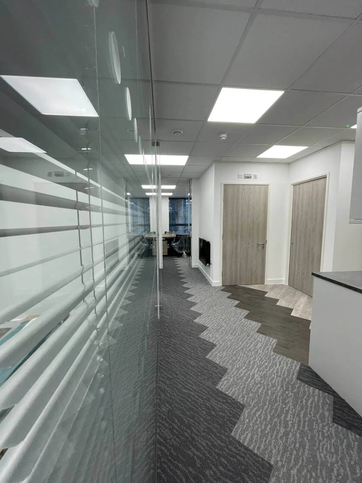 Hemsley Miller office space with designer flooring, funriture and single glazed glass partitions 17